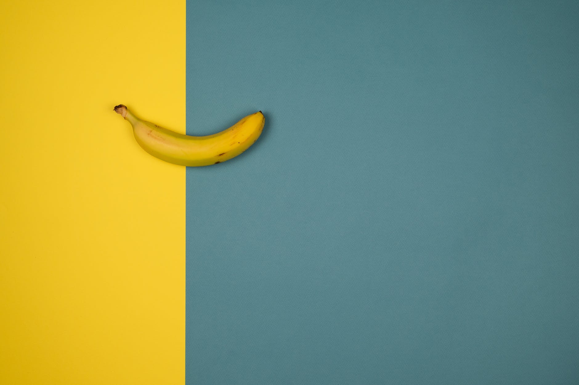 Contrast image of a banana on a yellow and blue background